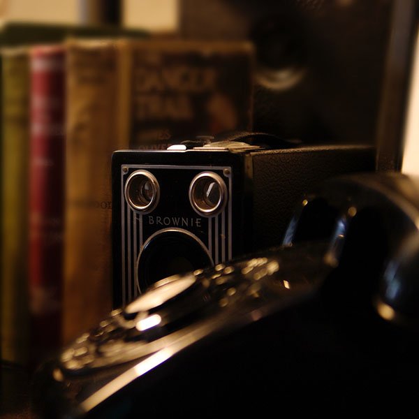 vintage telephone with books and a vintage camera in the background
